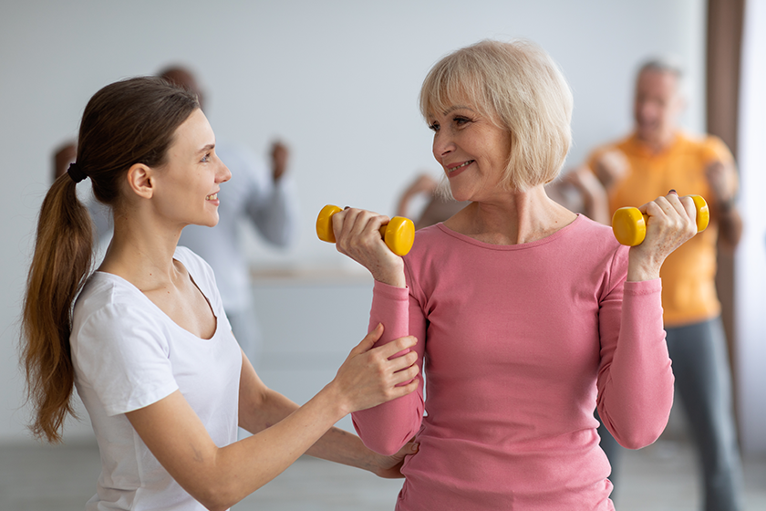 fitness-instructor-assisting-multiracial-group-of-elderly-people